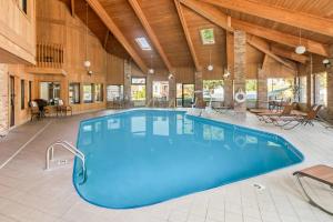 a large swimming pool in a large room with wooden ceilings at Quality Inn East Liverpool - Calcutta in East Liverpool