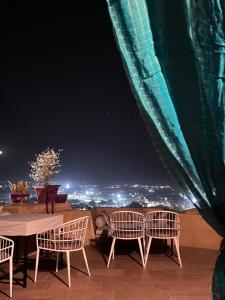 a table and chairs on a balcony at night at Hotel Surja Jaisalmer in Jaisalmer +34 photos