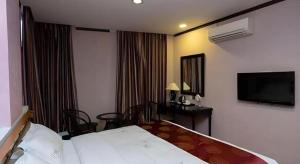 a hotel room with a bed and a desk and a television at S Bee Hotel in Johor Bahru