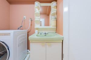 綺麗に改装されたアパートメント 京都や新大阪駅へアクセス良好 3ベッド 1バスルーム في أوساكا: حمام مع مغسلة وغسالة ملابس +61 صورة