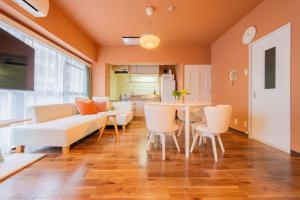 綺麗に改装されたアパートメント 京都や新大阪駅へアクセス良好 3ベッド 1バスルーム في أوساكا: غرفة معيشة مع أريكة وطاولة وكراسي