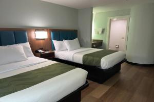 a hotel room with two beds and a hallway at Wingate by Wyndham Macon I-475 in Macon +3 photos