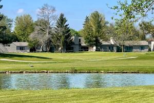 a house on a golf course with a pond at Bay Valley Resort & Conference Center in Bay City
