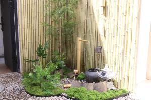 un jardin devant une clôture en bambou dans l'établissement Suzhou Garden Nook Pingjiang Laneway Hideaway, à Suzhou