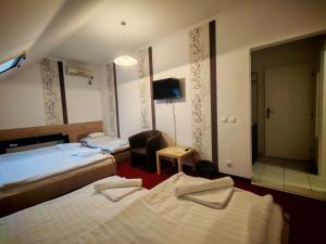 a hotel room with two beds and a mirror at Menta Rooms & Bar in Kapuvár
