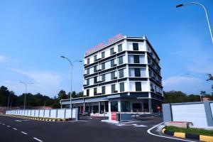 a large white building in a parking lot at Star-Well hotel in Kuala Lipis