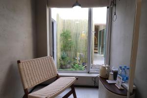 Una habitación con una silla y una mesa y una ventana. en Suzhou Garden Nook Pingjiang Laneway Hideaway, en Suzhou 43 fotos más