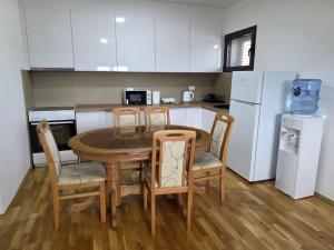 a kitchen with a table and chairs and a refrigerator at Lakeside View in Kuside +2 photos