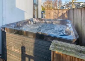 Un bain à remous est installé au-dessus d'une clôture en bois. dans l'établissement Cleveland Hills View Holiday Park, à Middleton upon Leven 53 autres photos