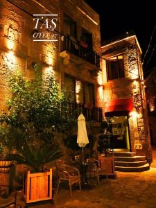 a building with a table and chairs in front of it at Tas Otel 17 in Behramkale