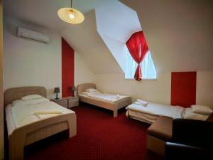a room with two beds and a window and a couch at Menta Rooms & Bar in Kapuvár