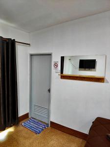 Cette chambre dispose d'une porte et d'une télévision murale. dans l'établissement Aladdin Guest House, sur les Îles Phi Phi