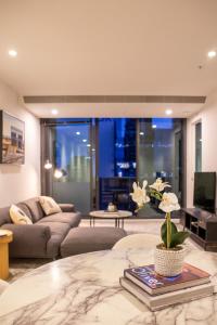 a living room with a couch and a table at Balcony, Free Parking, Workspace, Shared Pool & Gym in Melbourne