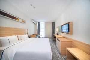une chambre d'hôtel avec un grand lit et une télévision dans l'établissement City Comfort Inn Wuhan Rui'an Street Metro Station, à Wuhan 155 autres photos