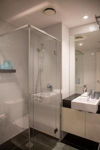 a bathroom with a glass shower and a sink at Balcony, Free Parking, Workspace, Shared Pool & Gym in Melbourne