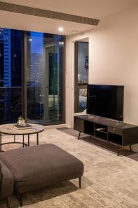 a living room with a large flat screen tv at Balcony, Free Parking, Workspace, Shared Pool & Gym in Melbourne +13 photos