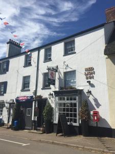 um edifício branco ao lado de uma rua em Red Lion Inn em Sidbury