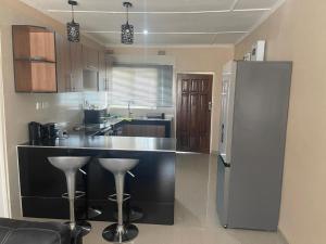 卢萨卡Sofies's Apartments的厨房配有黑色柜台和冰箱。