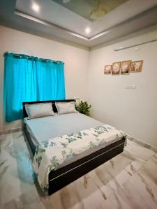 a bedroom with a bed with blue curtains at Vididhi By N - 2BHK Neo Stay in Kottapeta