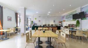 a dining room with tables and chairs in a restaurant at GreenTree Inn Yancheng Dongtai West Wanghai Road Shell Hotel in Dongtai