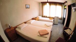 um quarto de hotel com duas camas e uma janela em Atanasovi House em Shkorpilovtsi