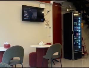 a room with a table and chairs and a tv at Easy Hotel - 1 min Train Station in Hat Yai