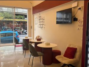 a restaurant with two tables and chairs and a window at Easy Hotel - 1 min Train Station in Hat Yai