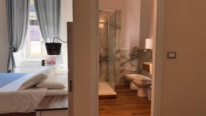 a bathroom with a bed and a toilet and a shower at Bed and Chic art rooms in Trieste
