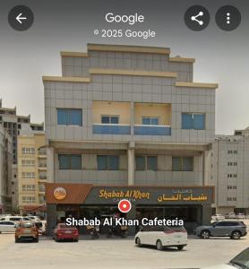 a building with cars parked in a parking lot at Elegant Private Rooms in a Penthouse with Free Parking in Sharjah