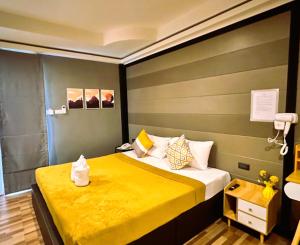 a hotel room with a bed with a yellow blanket at Viphuanan Resort in Nong Prue