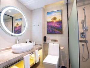 ein Badezimmer mit Waschbecken, Toilette und Spiegel in der Unterkunft Lavande Hotel Foshan Shunde Shunlian Plaza Jinlong Metro Station in Shunde + 127 Fotos