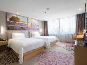 ein Hotelzimmer mit zwei Betten und einem Gemälde an der Wand in der Unterkunft Lavande Hotel Foshan Shunde Shunlian Plaza Jinlong Metro Station in Shunde