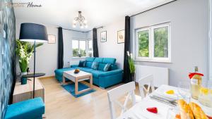 a living room with a blue couch and a table at Apartamenty z balkonami, blisko wyciągów i centrum in Karpacz +34 photos