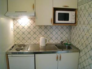 a small kitchen with a sink and a microwave at Résidence La Villa Léonie in Nice
