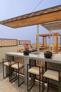 an outdoor kitchen with a bar with stools at VESTA - New Cairo Residence in New cairo