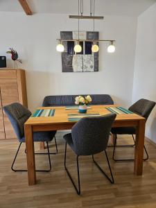 une salle à manger avec une table et des chaises en bois dans l'établissement Lechbruck am See Feriendorf Hochbergle Haus 142 - Lechseeblick, à Lechbruck am See