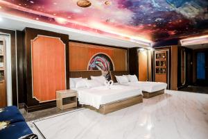 una camera da letto con due letti e un soffitto con un universo di Underskies Spa and Hotel a Sampong
