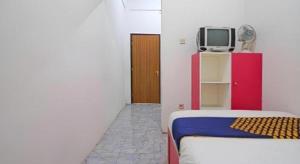 a room with a bed and a tv on a shelf at SPOT ON 91993 Pondok Hs Padalarang Syariah in Simpar +88 photos