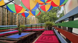 a patio with colorful tables and colorful umbrellas at Tuaran Village Guesthouse in Tuaran