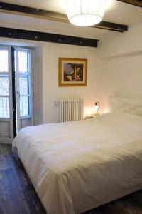 a large white bed in a room with a window at San Francesco Suite in Poggio Bustone