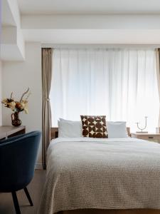 a bedroom with a large bed and a blue chair at RARE-EBISU BREEZE Apartment in Tokyo