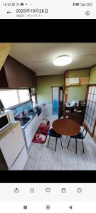 a kitchen and dining room with a table and a table and chairs at さんこ戸建て1号棟 in Takamatsu
