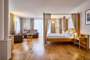 une chambre avec un lit à baldaquin et un salon dans l'établissement Hanusel Hof Wellness & Genuss in Panoramalage, à Hellengerst 95 autres photos
