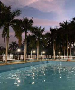 einen Swimmingpool mit Palmen in der Nacht in der Unterkunft Khách sạn Hiệp Thạnh in Buon Ma Thuot