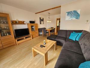 un salon avec un canapé et une table dans l'établissement Lechbruck am See Feriendorf Hochbergle Haus 142 - Lechseeblick, à Lechbruck am See