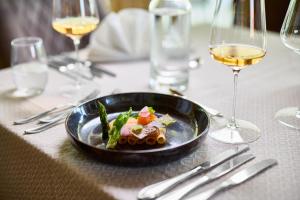 a plate of food on a table with wine glasses at Hanusel Hof Wellness & Genuss in Panoramalage in Hellengerst