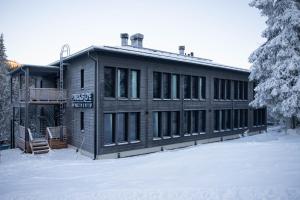 un edificio in legno nella neve con neve di Ski-inn Parkside a Kuusamo