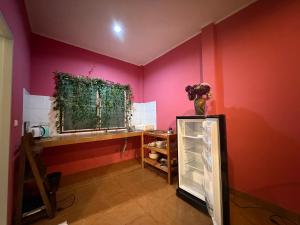 a room with pink walls and a shelf and a window at Mandala bungalow at Ya Nui beach in Rawai Beach