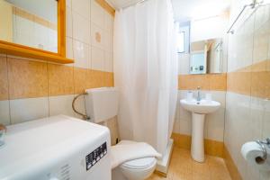 ein kleines Badezimmer mit Toilette und Waschbecken in der Unterkunft Beachfront Cozy Apartments in Ammoudara + 27 Fotos