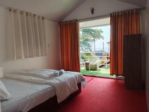 a bedroom with a bed and a large window at Casa fiesta patnem in Patnem